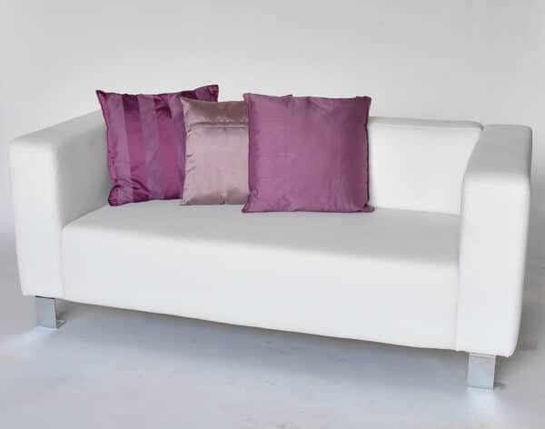Canapé en simili cuir blanc qui pourra être utilisé pour créer un espace salon convivial